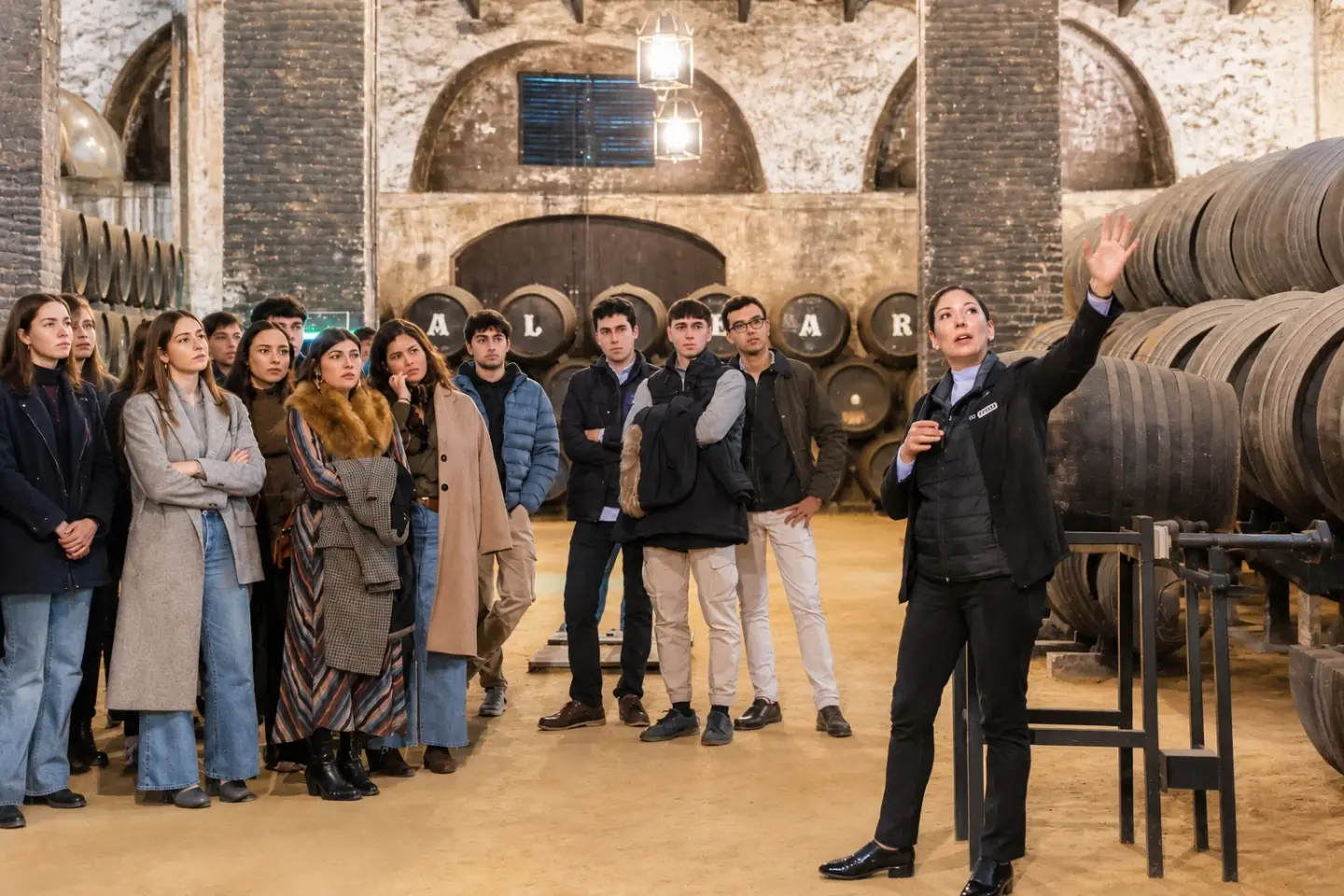 Visita cultural de residentes de Puertanueva a Bodegas Alvear: guía explicando el proceso de elaboración ante el grupo